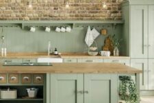 a sage green farmhouse kitchen with a beadboard backsplash and butcherblock countertops, a large kitchen island with storage compartments