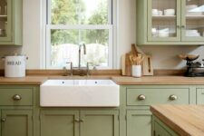 a sage green kitchen with shaker cabinets, butcherblock countertops, a large matching kitchen island is welcoming