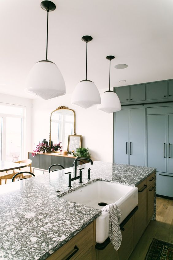 a slate grey kitchen with flat panel cabinets, a stained kitchen island with a black terrazzo countetop and black fixtures