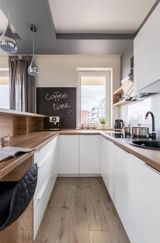 a sleek white kitchen with butcherblock countertops, open shelves and cabinets and a bar counter and workspace in one