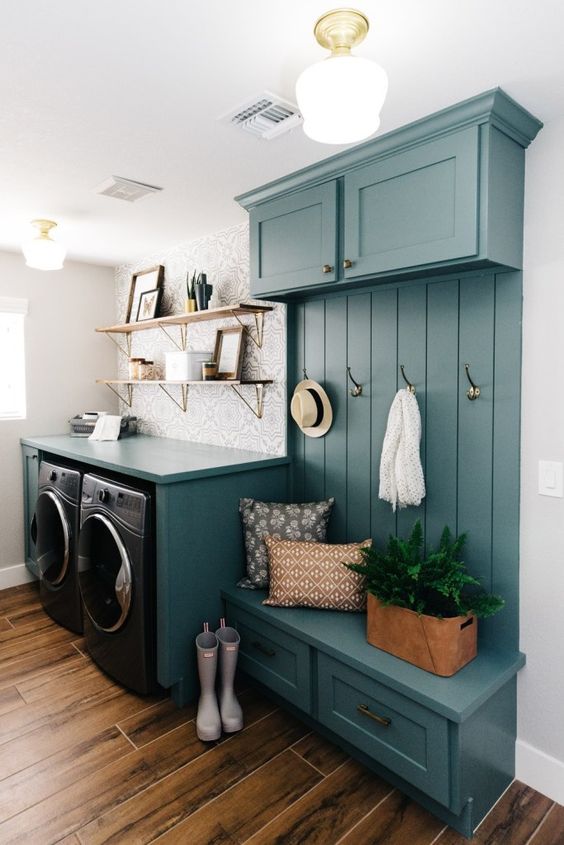 a small yet bright blue mudroom laundry with cabinets, an open storage unit, a washing machine and a dryer and open shelves