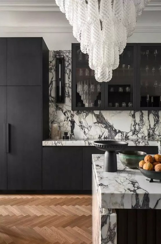 خزائن مطبخ زجاجية A-sophisticated-black-and-white-kitchen-with-matte-black-cabinets-and-white-marble-countertops-and-a-backsplash-plus-a-stunnign-crystal-chandelier