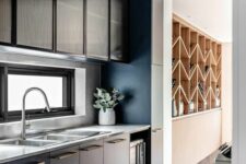 a sophisticated black kitchen with flat panel cabinets and ribbed glass ones, a window backsplash and white countertops is pure elegance