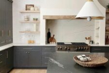 a stylish graphite grey kitchen with shaker cabinets, white countertops, open shelves, a built-in hood and a black soapstone countertop on the kitchen island