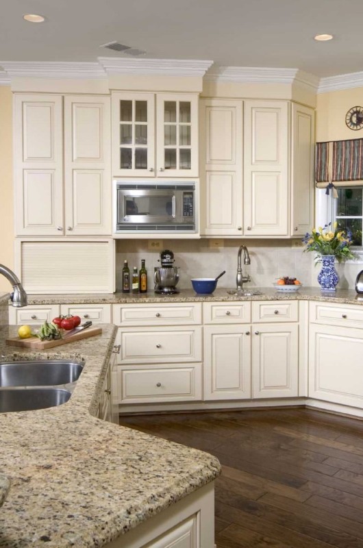 a traditional creamy kitchen with shaker cabinets, a matching tile backsplash and grey granite countertops