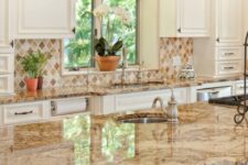 a vintage kitchen with white shaker cabinets, a tan and beige tile backsplash, a stained kitchen island and beige granite countertops