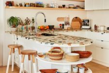a vivacious white kitchen with flat panel cabinets, a colorful terrazzo countertop, open shelves for displaying dishes
