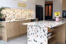 a white and light stained kitchen with a bright terrazzo backsplash and countertops on the cabinets and on the kitchen island