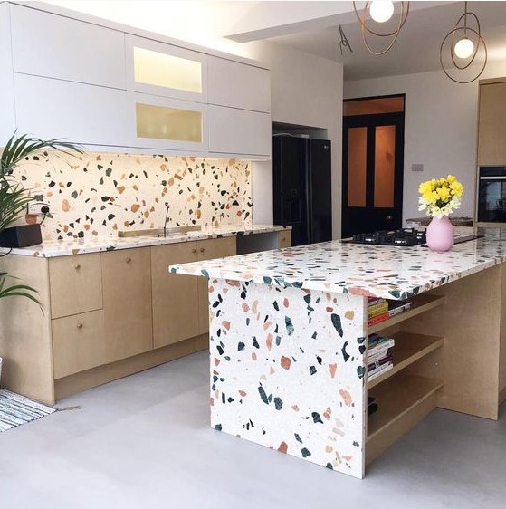 a white and light stained kitchen with a bright terrazzo backsplash and countertops on the cabinets and on the kitchen island