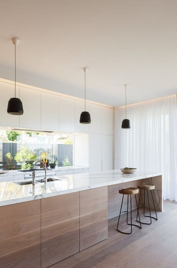a white minimalist kitchen with a window backsplash, a stained kitchen island and black pendant lamps plus wooden stools