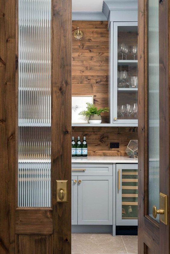 stained doors with ribbed glass inserts and brass fixtures are amazing for a chic country house