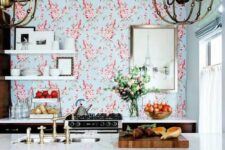 04 a bright and catchy space with only lower cabinets, with bright floral wallpaper, open shelving,a kitchen island with seating and large chandeliers