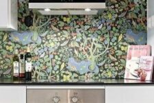 08 a minimalist black and white kitchen spruced up with a dark floral wallpaper backsplash is a stylisha dn cool space to cook in