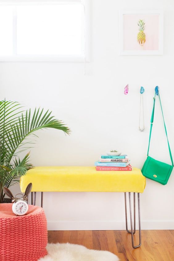 a super bold yellow upholstered nehc with hairpin legs will add a touch of color to your bedroom or entryway