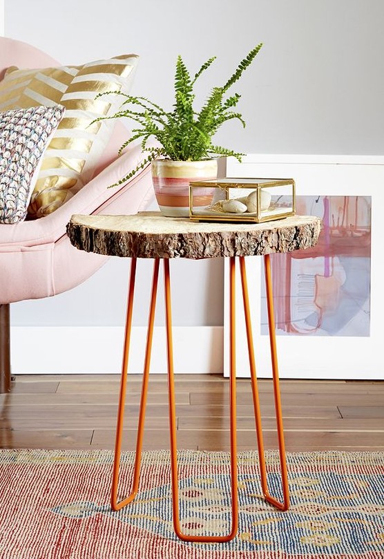 a side table of a tree slice and orange hairpin legs is a cool decor piece for a living room in mid-century modern style