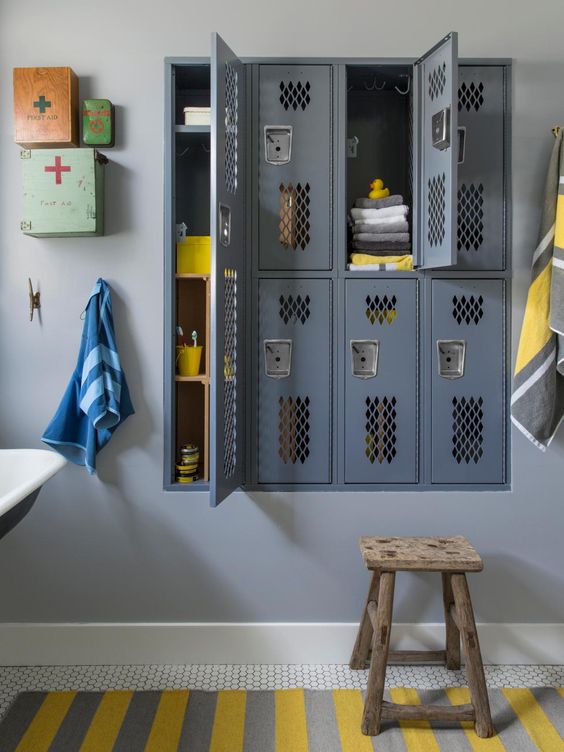 a vintage-inspired bathroom with grey built-in lockers, bright mini cabinets and a bold striped rug is a cool idea