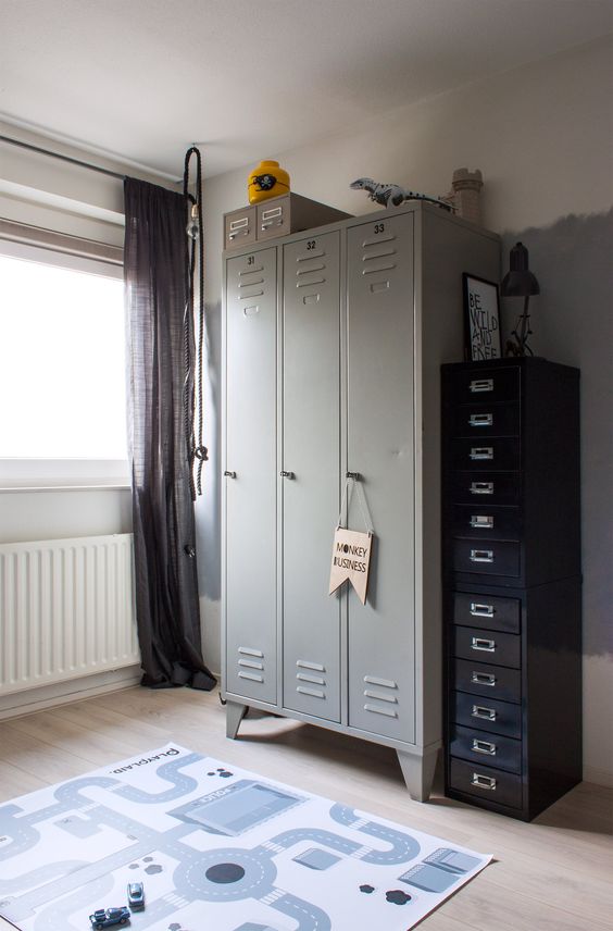 a kid's space finished off with grey lockers, with black flie cabinets that provide a lot of storage space