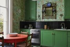 21 a bold vintage kitchen with bright green cabinets, bright floral wallpaper, black tiles on the backsplash, a checked floor and a round red table