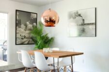 29 a mid-century modern dining room with a hairpin leg dining table, white chairs, a printed rug, a copper pendant lamp and some art
