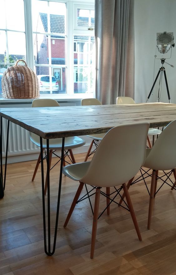 a Nordic dining space with a hairpin leg dining table, white Eames chairs and a basket on the windowsill