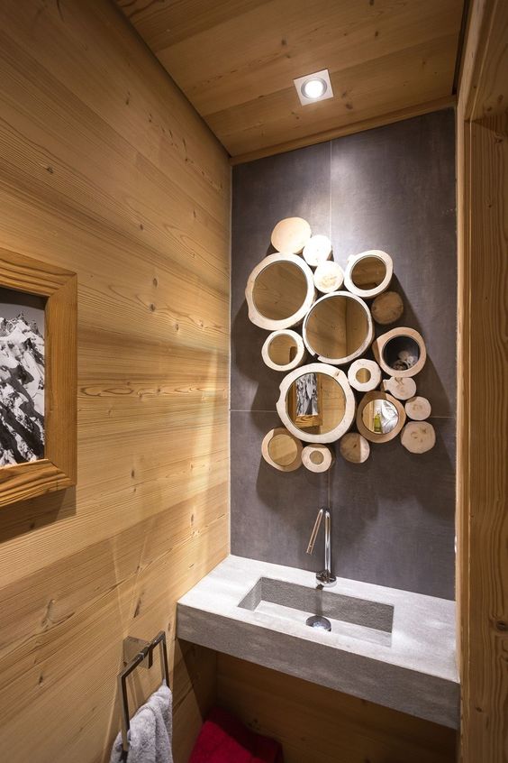 a creative rustic wall art of tree slices with mirrors inside is a great alternative to a usual mirror in a bathroom