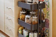31 a neutral kitchen with a bright floral wallpaper wall, a dark trolley and a white square tile backsplash is a stylish space