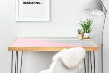 32 a pink and stripe color block desk with hairpin legs, a white chair, a grey floor lamp and an artwork  for working