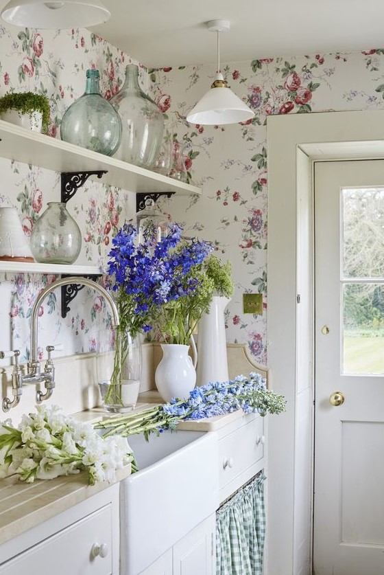 a vintage farmhouse kitchen in neutrals and with lovely pink and blue floral wallpaper that creates a mood here