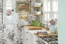 33 a vintage kitchen with white shaker cabinets, a black and white floral wallpaper wall, butcherblock countertops, open shelves and a subway tile backsplash