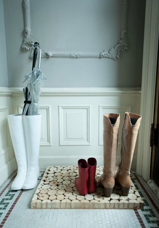 a creative tree slice tray for shoes and boots will keep your entryway clean and will add a rustic feel to it