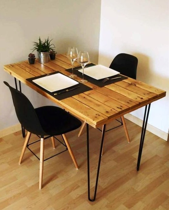 a small and comfy dining table with a pallet tabletop and black hairpin legs looks very chic, black chairs add to it