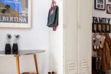 51 a pretty mudroom with a creamy locker, a rack, a mid-century modern coffee table, bold posters as artwork