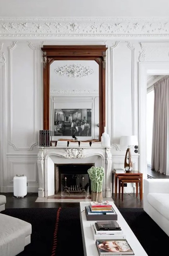 a French vintage fireplace with a metal stand and a glass screen for a cozy feel adds chic and interest to this refined living room