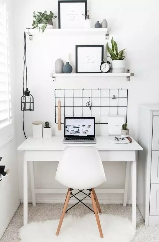 a Nordic home office nook done in white and accented with a black grid on the wall, a pendant lamp and Eames chair