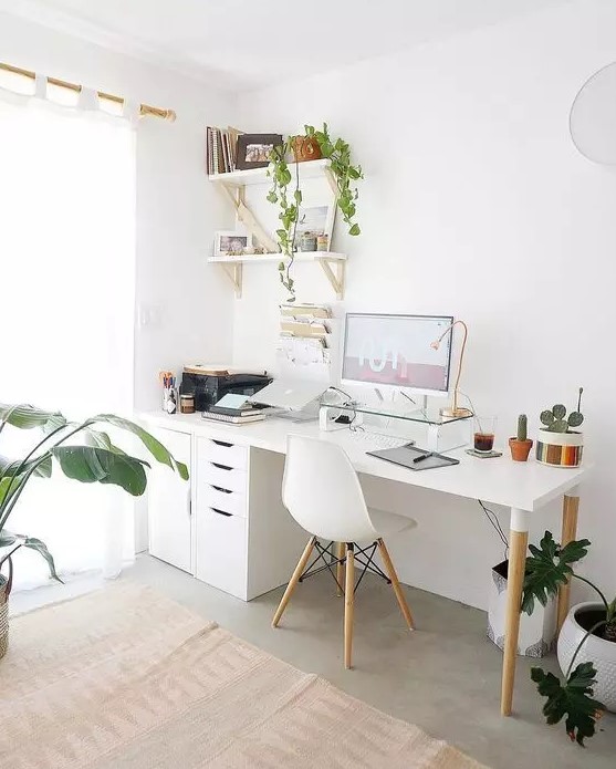 a Nordic home office with a white desk, file cabinets, a white Eames chair, wall-mounted shelves, potted plants and touches of gold