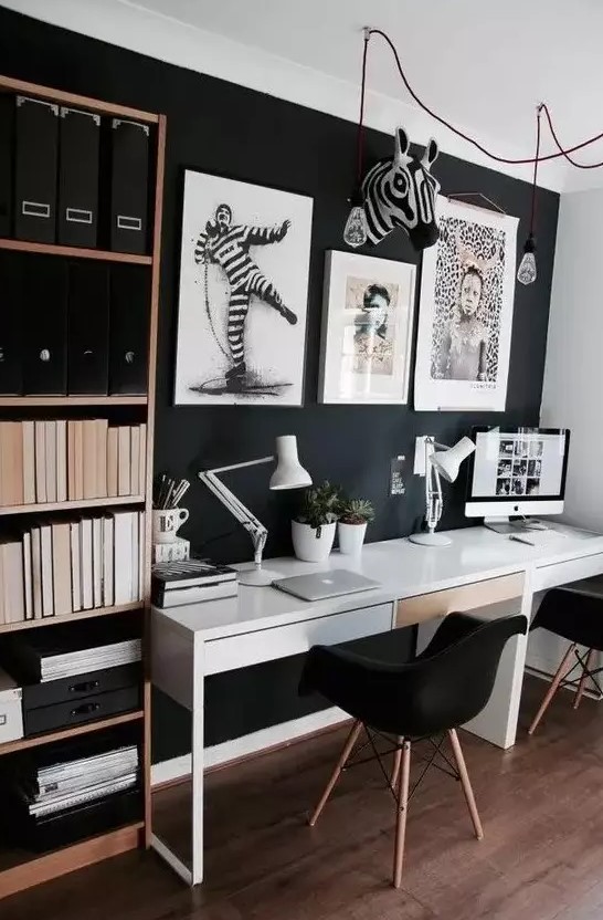 a Scandinavian home office with a black wall, a shelving unit and a shared white desk, bold artworks for cool wall decor
