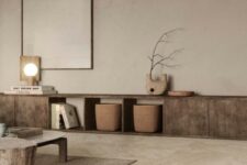 a beautiful and airy living room with textural grey walls and a stone tile floor, a low stained credenza, a tree stump and a low coffee table