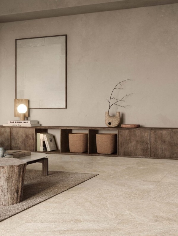 a beautiful and airy living room with textural grey walls and a stone tile floor, a low stained credenza, a tree stump and a low coffee table