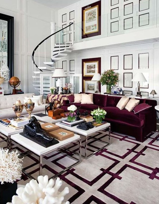 a beautiful living room with white paneled walls, a creamy and a purple sofa, a cluster of coffee tables and a printed white and purple rug