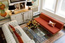 a bold refined living room with a white leather and orange fabric sofa and a statement gallery wall that creates a mood