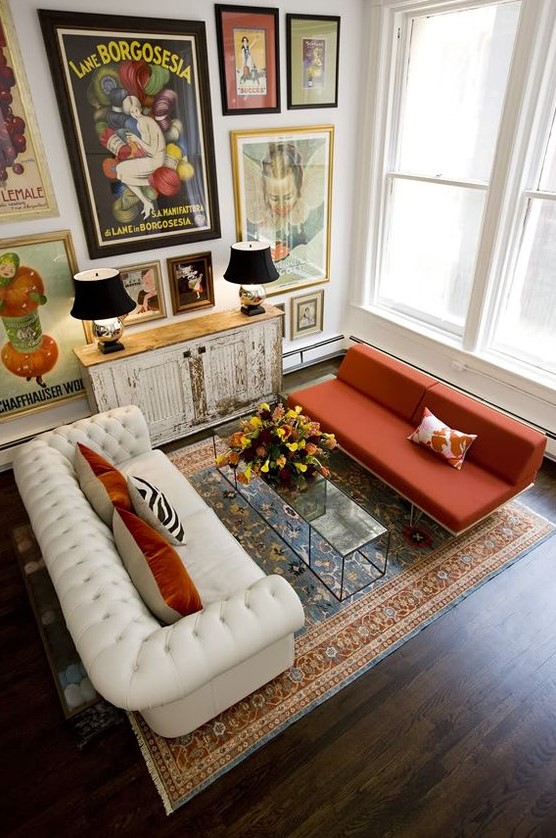a bold refined living room with a white leather and orange fabric sofa and a statement gallery wall that creates a mood
