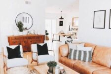 a bright boho living room with an amber leather sofa, a low coffee table, creamy chairs, jute poufs and potted plants