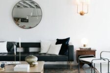 a chic Scandinavian living room with a black leather couch, a low coffee table, a white chair and a black leather daybed