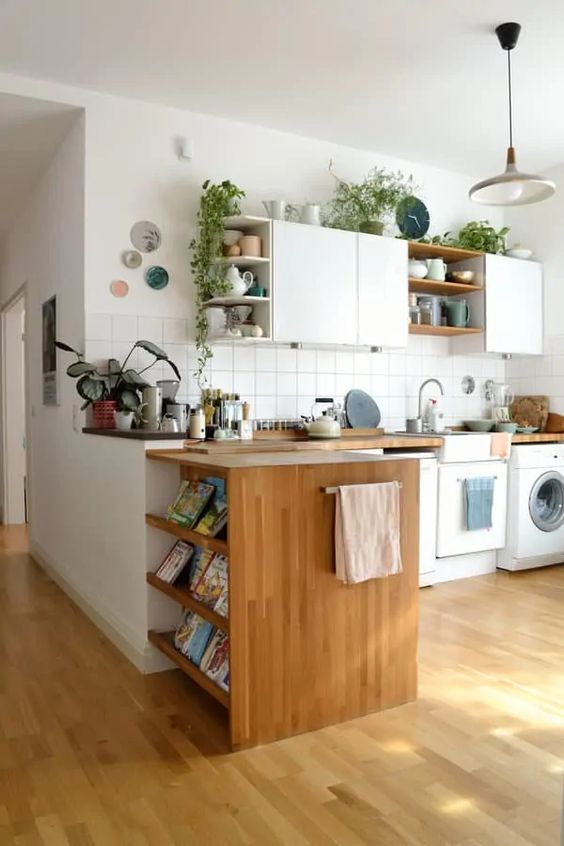 a cozy modern kitchen with flat white cabinets and open ones, stained shelves and butcherblock countertops, potted plants