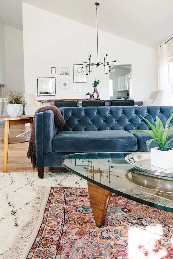 a farmhouse boho space with a muted blue velvet Chesterfield sofa that works as a space divider, too
