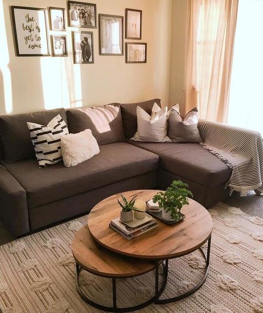 a farmhouse living room with a brown sectional, a duo of coffee tables, a black and white gallery wall is cool