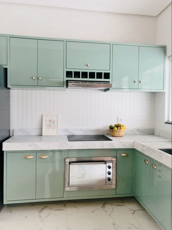 a glossy mint blue kitchen with flat panel cabinets, white stone countertops and a white embossed tile backsplash