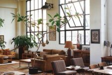 a lovely earthy tone open layout with rust and mustard furniture, grey chairs, stained tables and console tables and potted plants