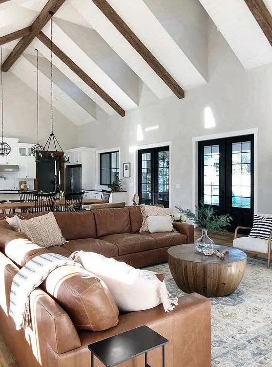a mid-century modern living room with a large brown leather sofa, a round coffee table and some decor