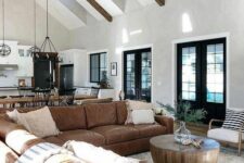 a mid-century modern living room with a large brown leather sofa, a round coffee table and some decor